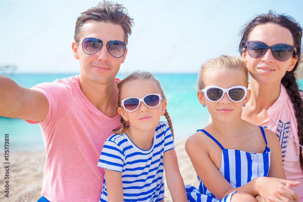 Young beautiful family taking selfie on the beach