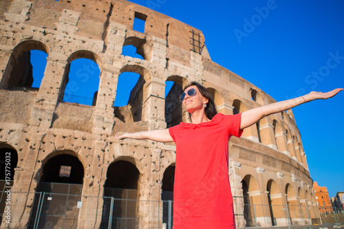 Adorable little active girl with map in front of Colosseum in Rome, Italy. Kid spending childhood in Europe