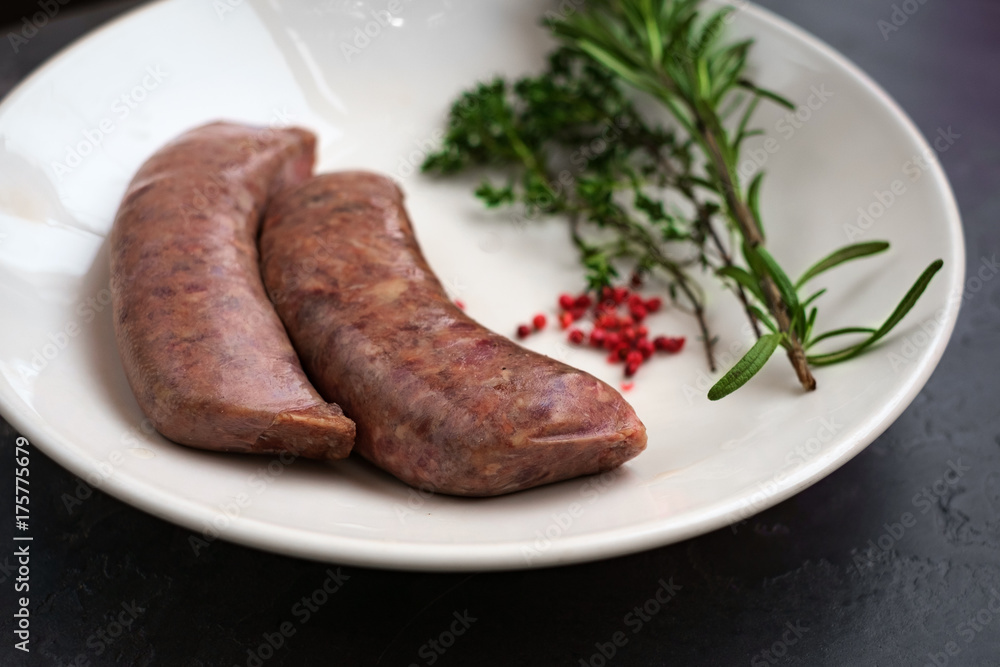 raw sausages for grilling on a plate