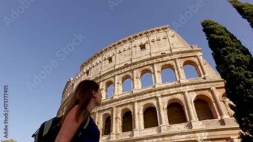 Woman walking in front of the colloseum in slow motion