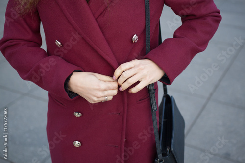 woman buttoning a button fall coat Burgundy
