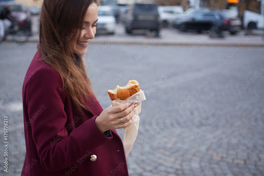 the girl on the street holding a cakes and laughs