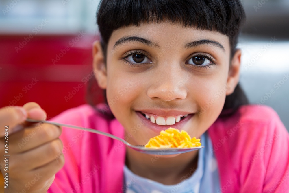 Close-up of portrait of girl holding cereal in spoon Close-up of portrait of girl holding cereal in spoon