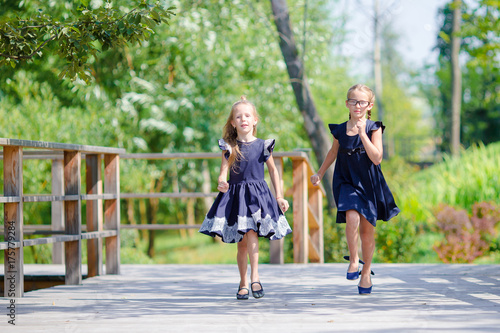 Adorable little school girls outdoors in warm september day. Back to school. © travnikovstudio