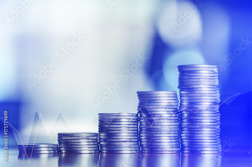 Double exposure Stacks of coins on working table with financial graph chart, finance and business concept,