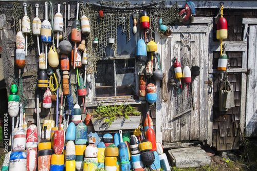 fishing wooden house with nets and buoys. colorful lobster buoys and fishnets hanged on wooden wall