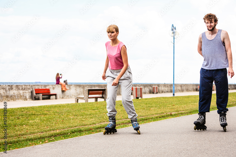Fototapeta premium Friends rollerblading together have fun in park.