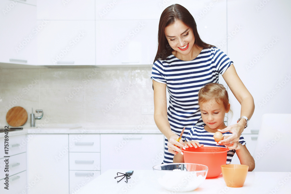 Adorable happy family makes cakes together on your white kitchen. Adorable happy family makes cakes together on your white kitchen.