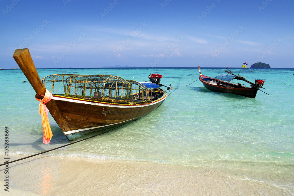 long tail boat, in white sand beach in  andaman sea