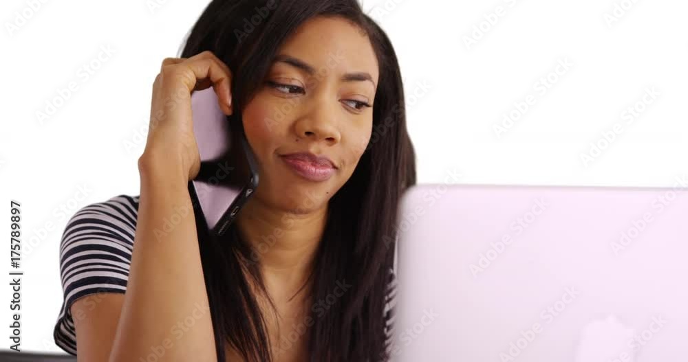 Close up of African American woman working on laptop and making phone call Close up of African American woman working on laptop and making phone call