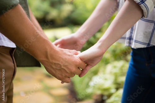 Mid-section of couple holding hands