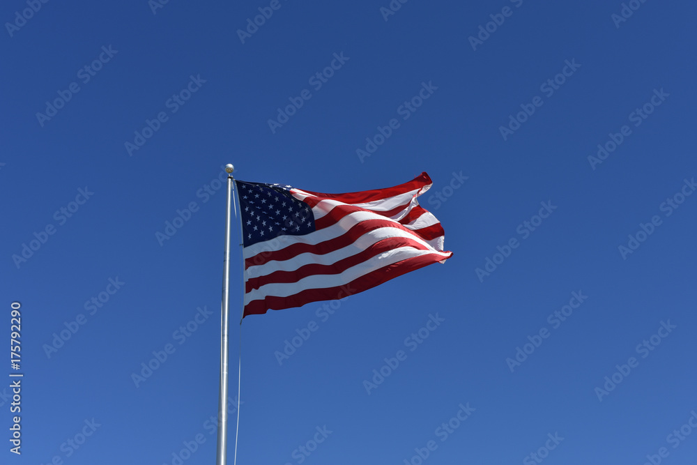 Giant United States of America Flag on clear blue sky with copy space