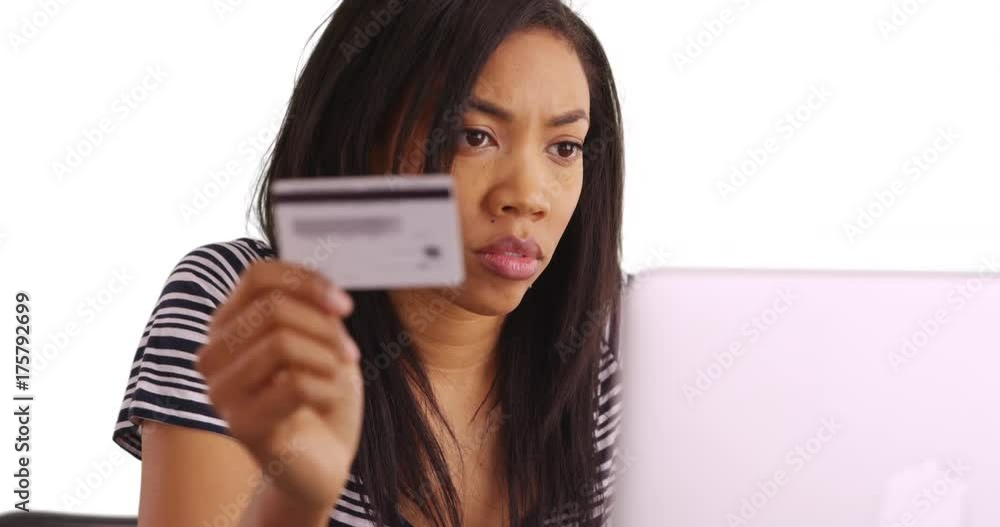 Close up of black female making online purchase with laptop in studio Close up of black female making online purchase with laptop in studio