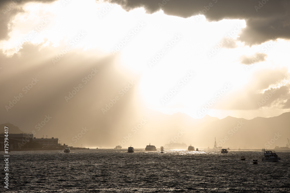 silhouette vessel traffic in Victoria harbour between Hong Kong island and kowloon at sunset with copy space