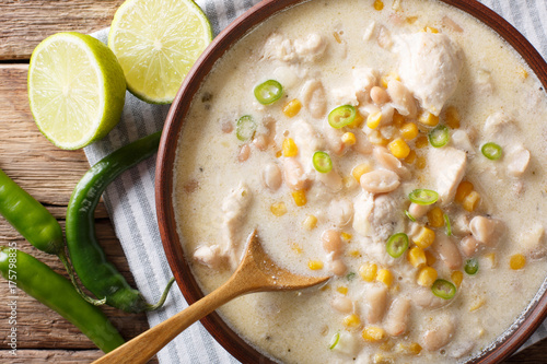 Slow cooker white chili chicken with beans and corn close-up on the table. horizontal top view