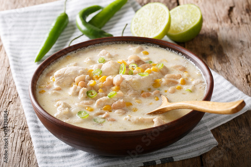 Homemade white chili chicken with beans, lime and corn close-up. horizontal