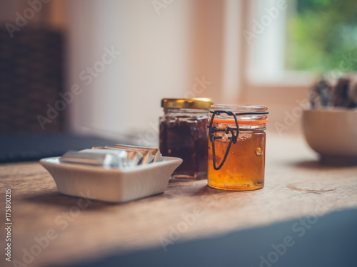 Jars of jam and butter on table