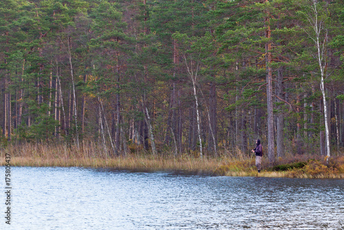 Fishermen at the forest lake in autumn photo