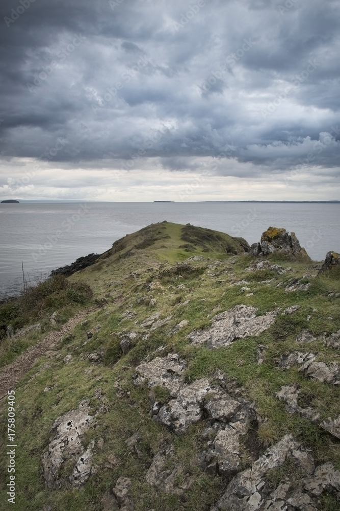 Looking out to sea at stormy dramatic sky over landscape