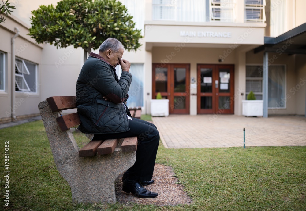 Depressed senior man sitting on bench