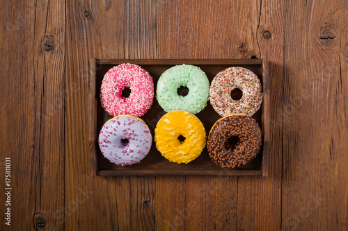 Colorful donuts on a wooden background.