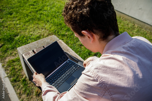 Young man with laptop in park