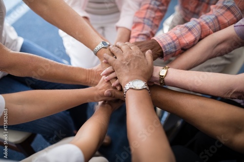 Картината върху платно Cropped image of senior people and female doctor stacking hands