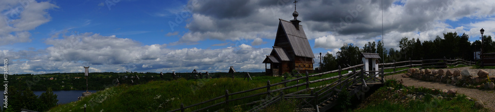 Wooden temple and rural cemetery on the hill/A wooden Orthodox church stands on a hill. Near the church there is an ancient rural cemetery with wooden crosses. Plyos, the Golden ring of Russia