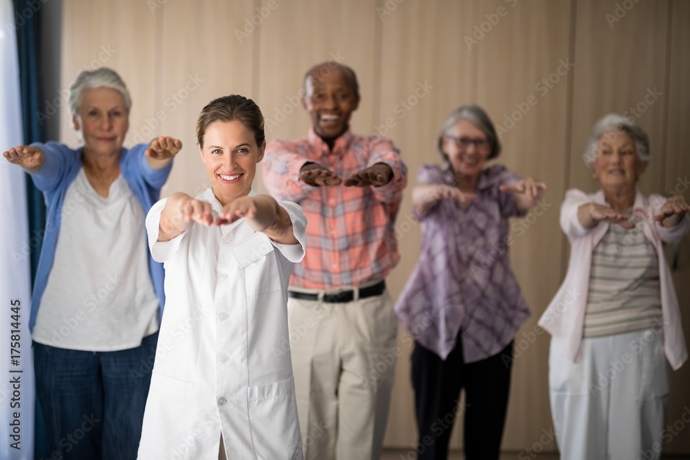 Portrait of smiling female doctor and seniors exercising Portrait of smiling female doctor and seniors exercising