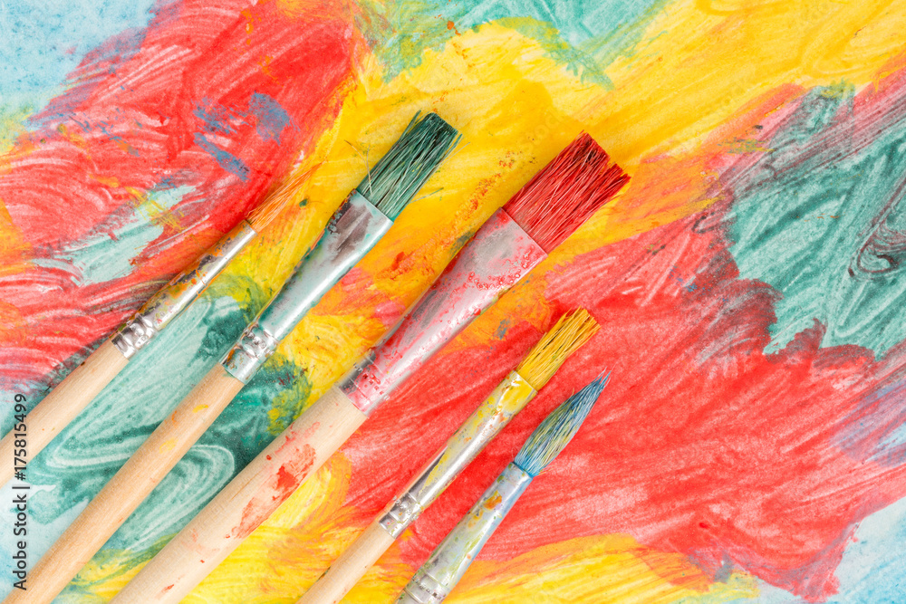 Fototapeta premium Five watercolor brushes on abstract painting