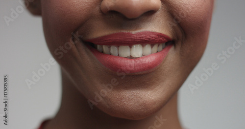 Close up shot of a face of a hot black model with short straight haircut serious then smiling warmly on white background