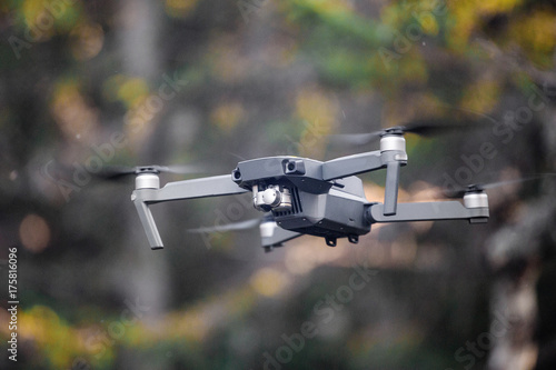 Modern black Remote control Drone or Quadcopter flying at forest background