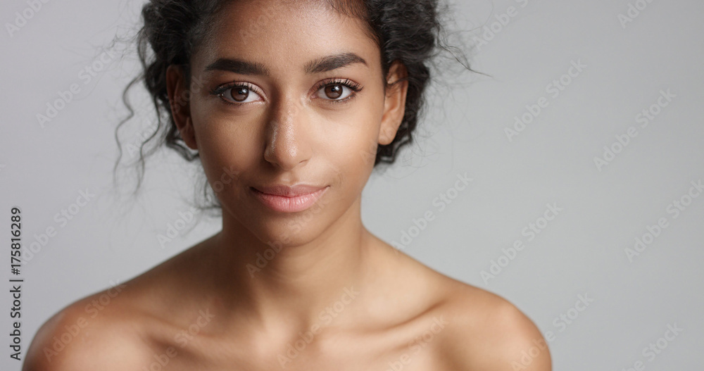 Fototapeta premium happy serene young woman with beautiful olive skin and curly hair ideal skin and brown eyes