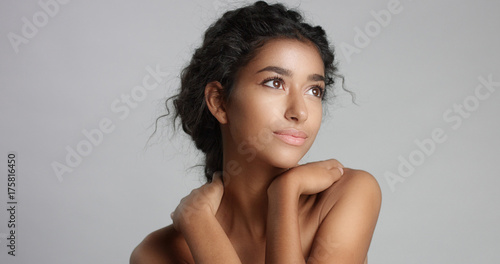 happy serene young woman with beautiful olive skin and curly hair ideal skin and brown eyes