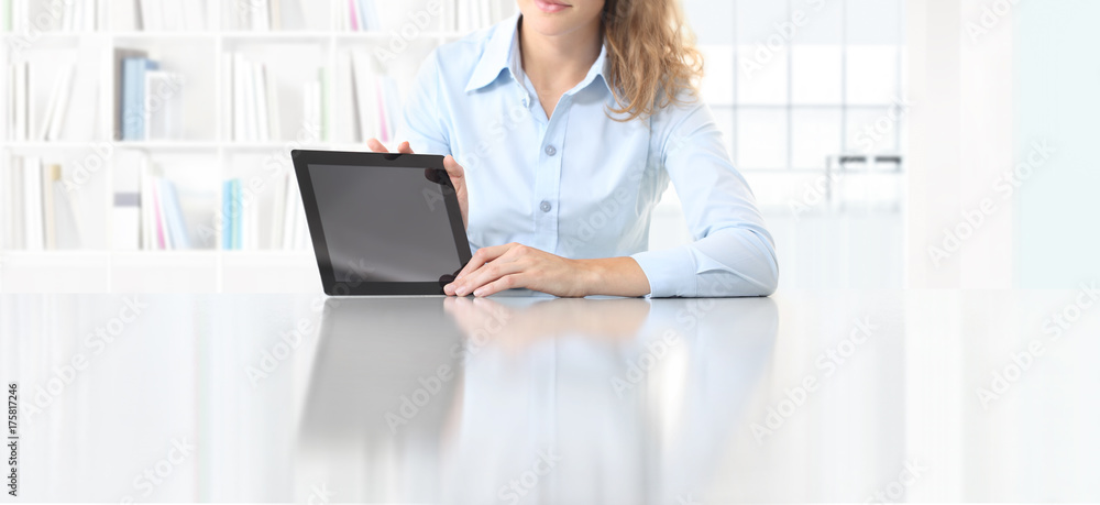 woman showing tablet sitting at desk woman showing tablet sitting at desk