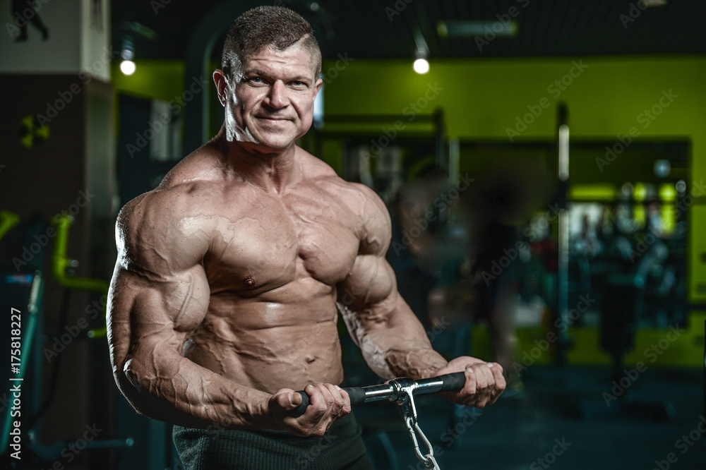 Handsome model young man training arms in gym Handsome model young man training arms in gym