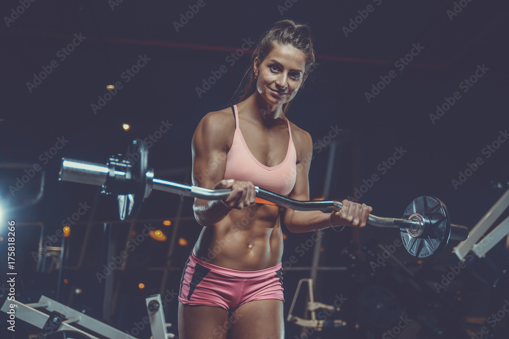 Sexy athletic young girl training arms in gym Sexy athletic young girl training arms in gym