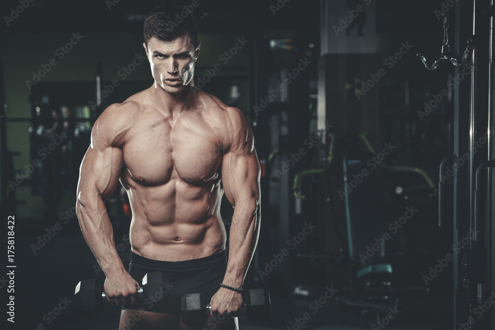 Handsome model young man posing in gym