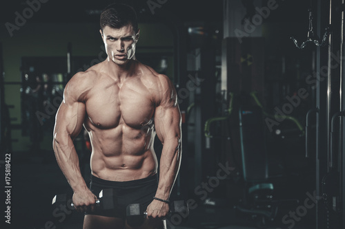 Handsome model young man posing in gym