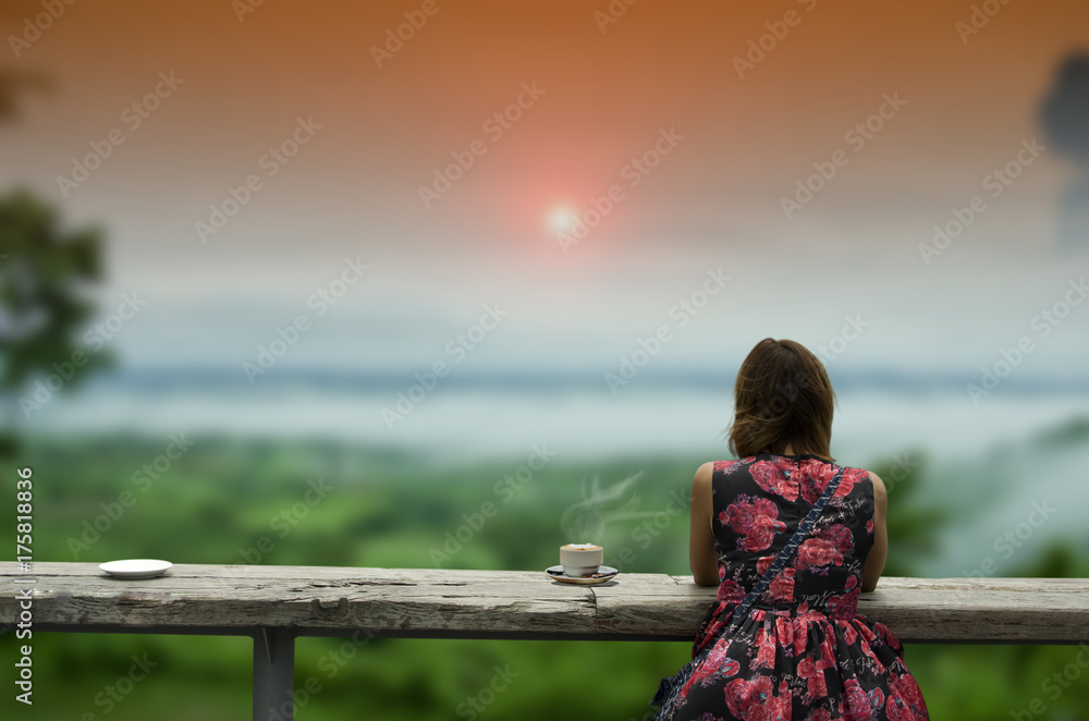 Women check in. beautiful coffee shop in forest fog and wooden table misty mountain and sunset