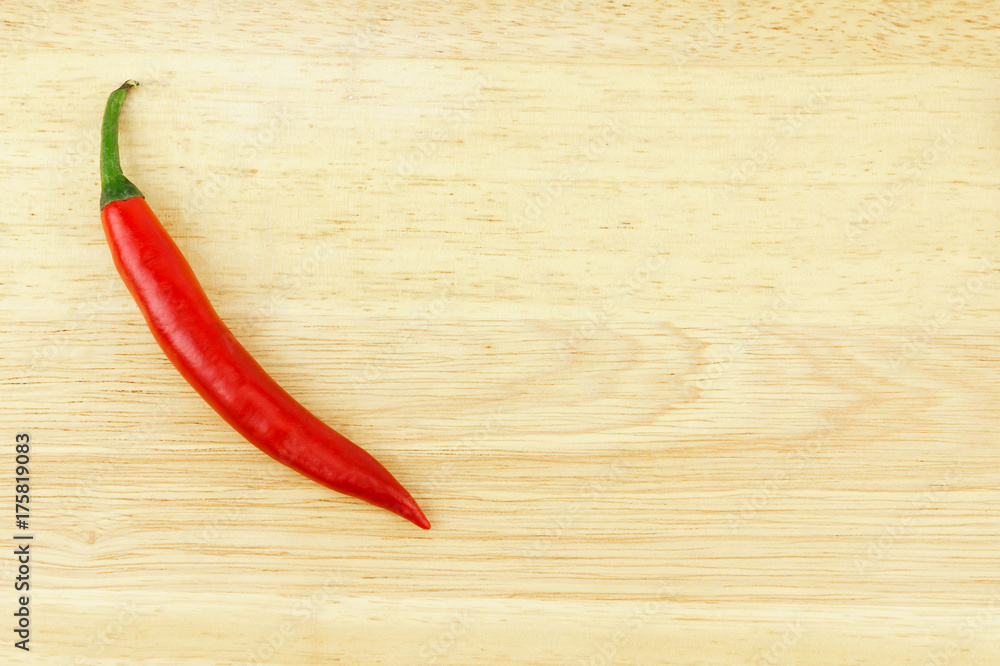 Red hot chili pepper on brown wood table with copy space