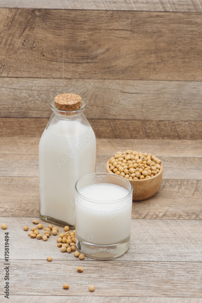 Bottle of soy milk and soybean on wooden table Bottle of soy milk and soybean on wooden table
