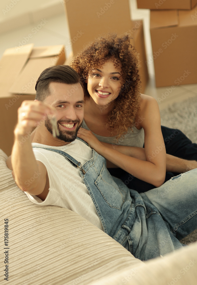 young couple holding the key to a new apartment young couple holding the key to a new apartment