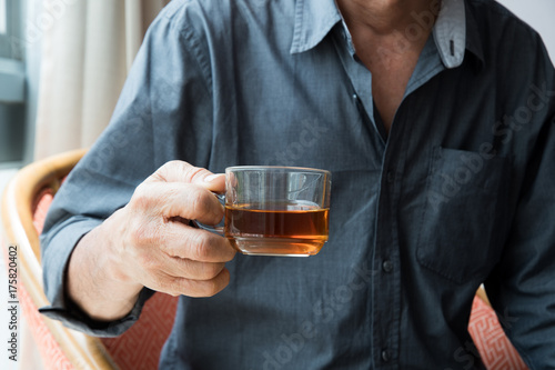 Male hand with cup of hot tea in morning