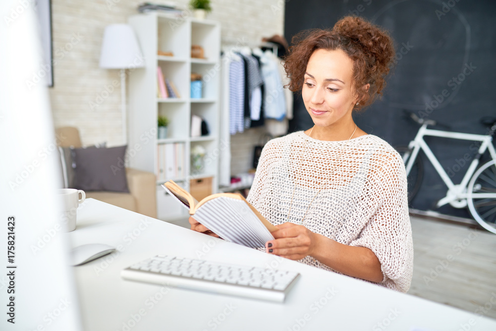 Portrait of beautiful mixed-race woman relaxing reading book while working from home in modern apartment Portrait of beautiful mixed-race woman relaxing reading book while working from home in modern apartment