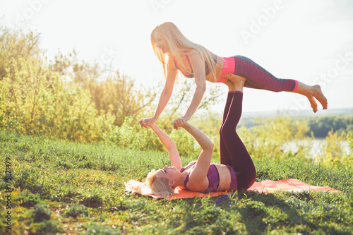 Couple Yoga, two woman doing yoga exercises in the park photo