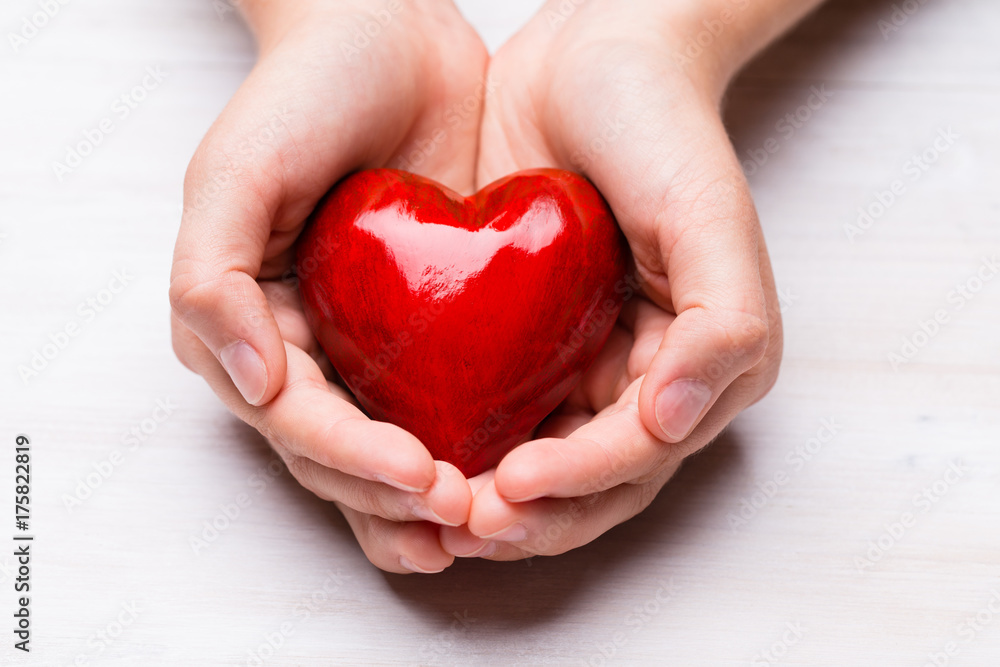 Fototapeta premium Red wood heart in child hands