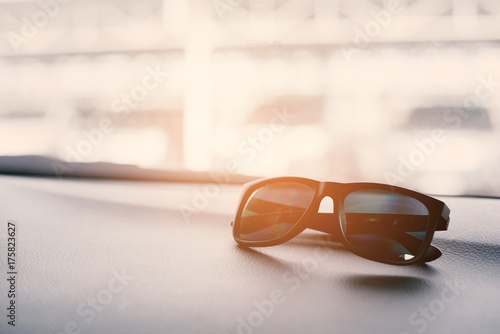 Black sunglasses on the front console of car on treaveling. Soft and split cross processing tone to retro vintage pinterest and instragram like process. photo