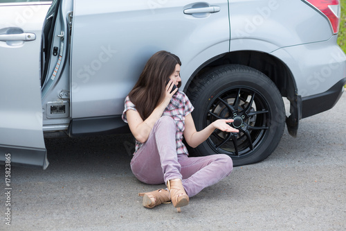 фотографія Woman With Flat tire On Car Phoning For Assistance
