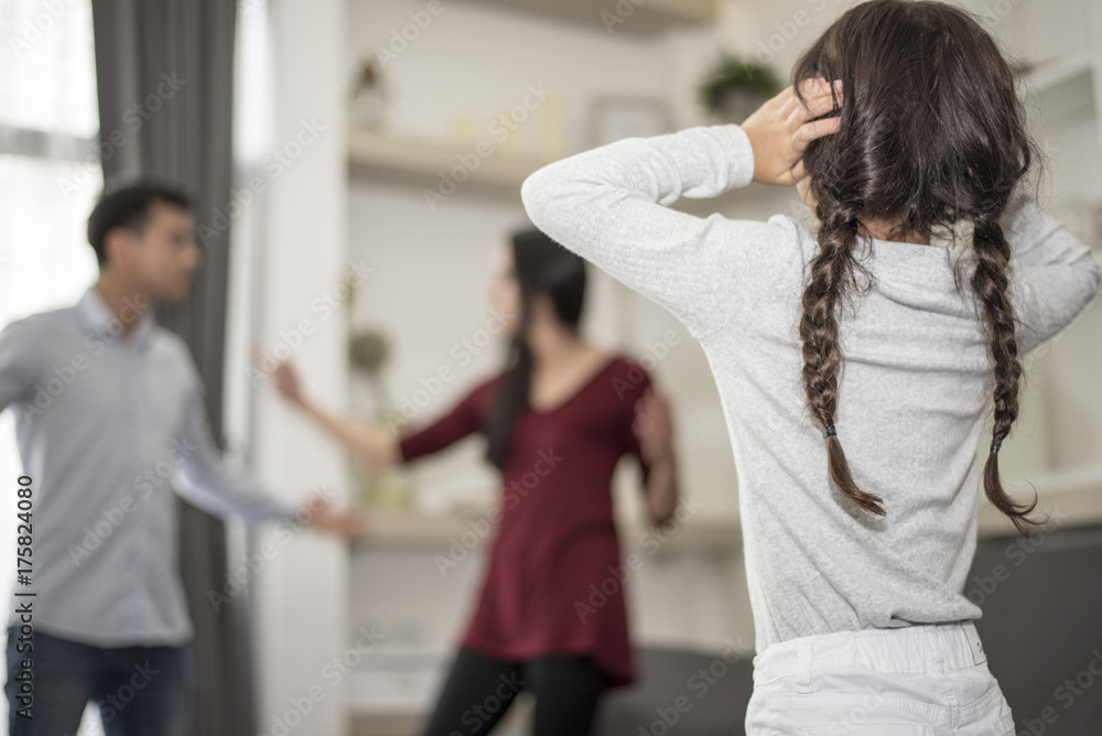 The girl puts her hands on her ear because she does not want to hear her parents quarrel. The girl puts her hands on her ear because she does not want to hear her parents quarrel.